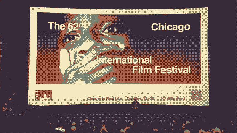 A large movie theater screen, showing a film festival promotional image of a man with his hand on his mouth